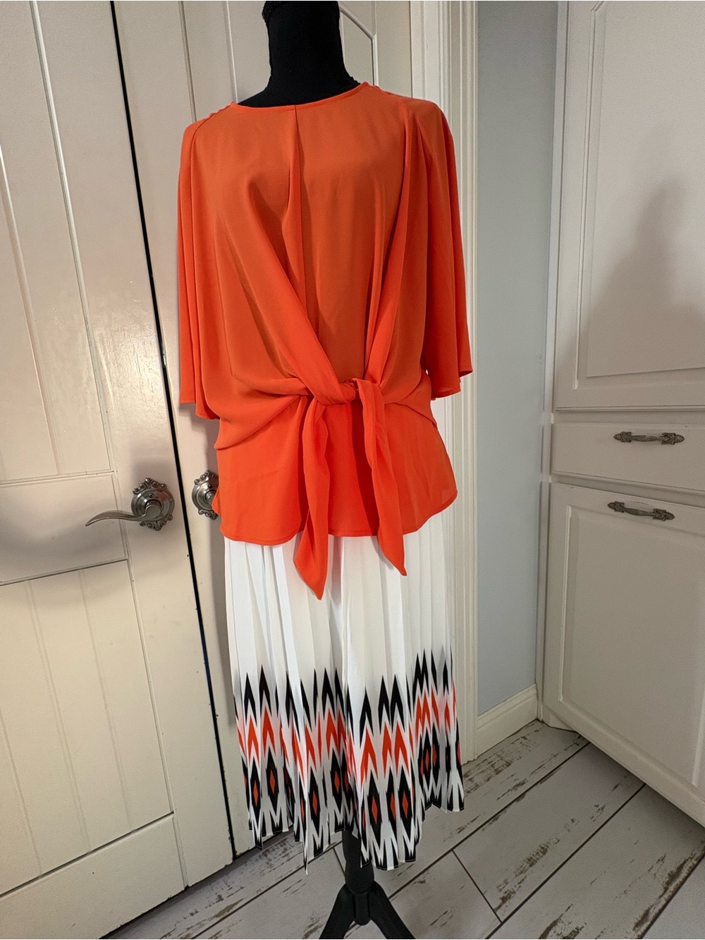 Worthington Orange Blouse with White and Black pleated Patterned Skirt